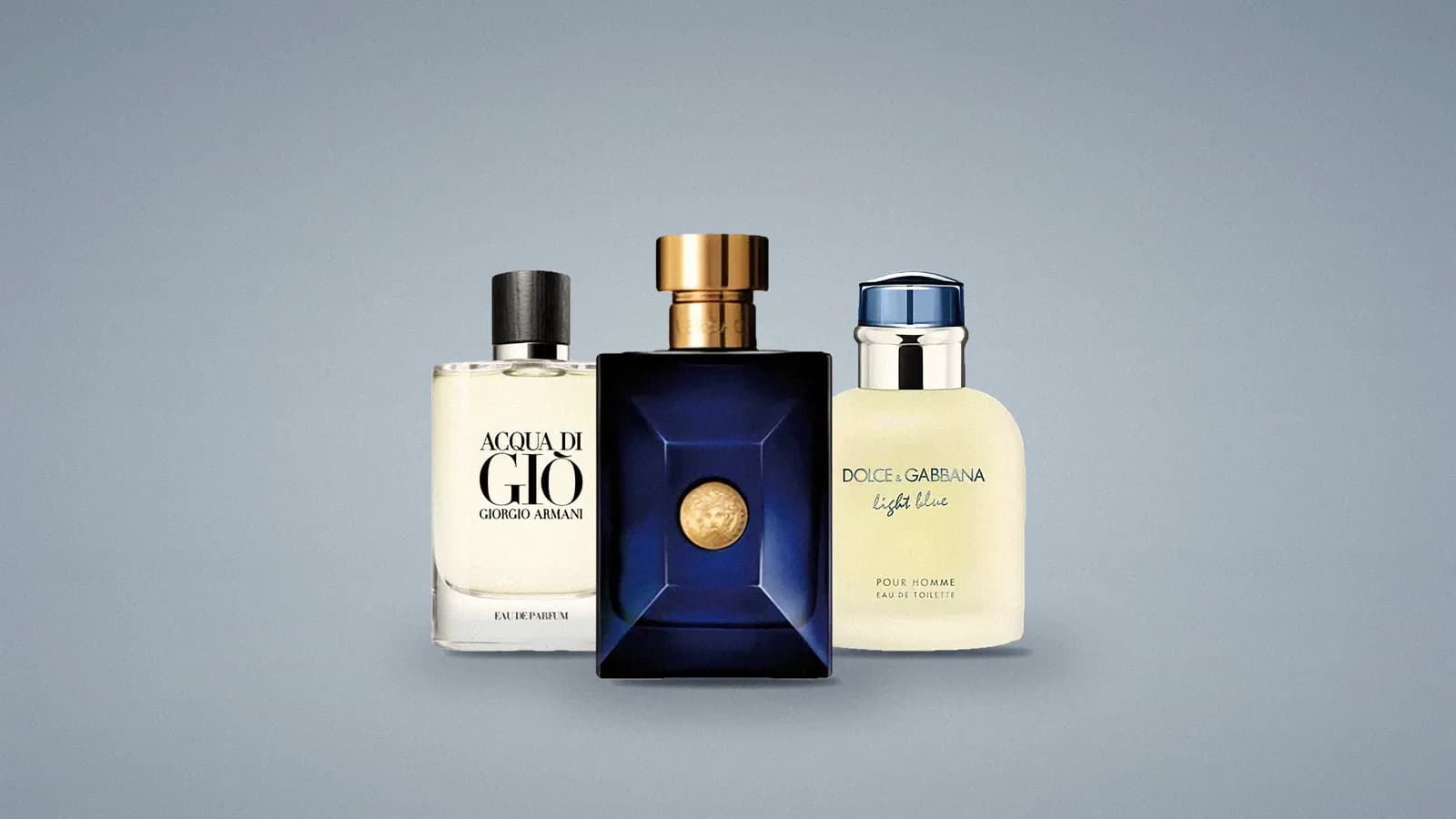 Our photos of three Alberto Morillas bottles on a soft blue-grey studio backdrop: Acqua di Giò on the left, the dark blue Versace Dylan Blue pour Homme in front, Dolce&Gabbana Light Blue pour Homme on the right