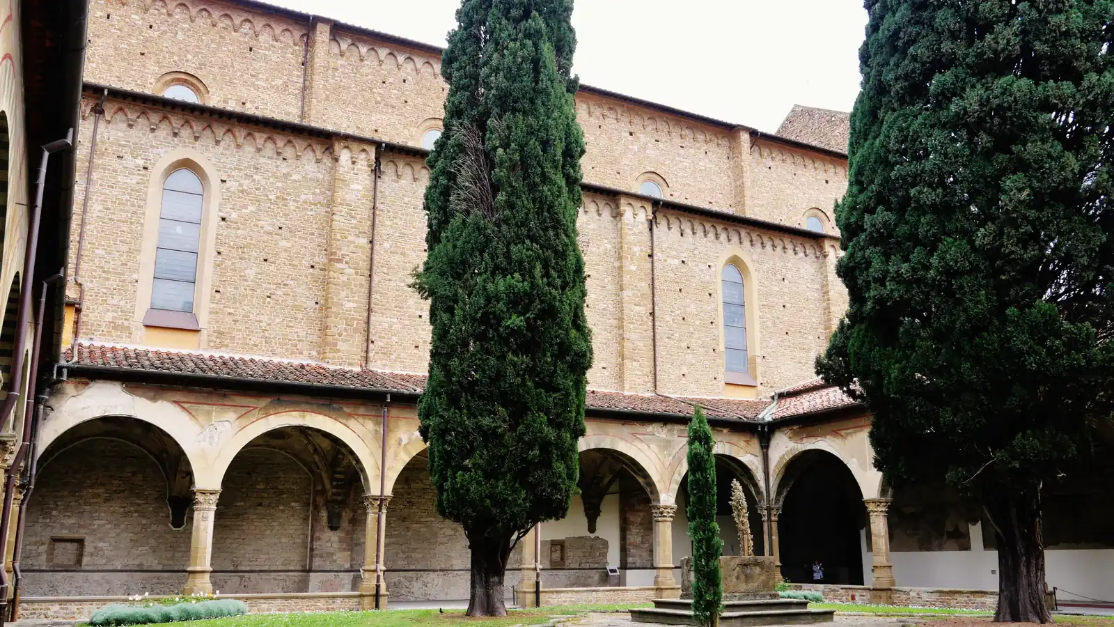 The green cloister of Santa Maria Novella in Florence with cypress trees